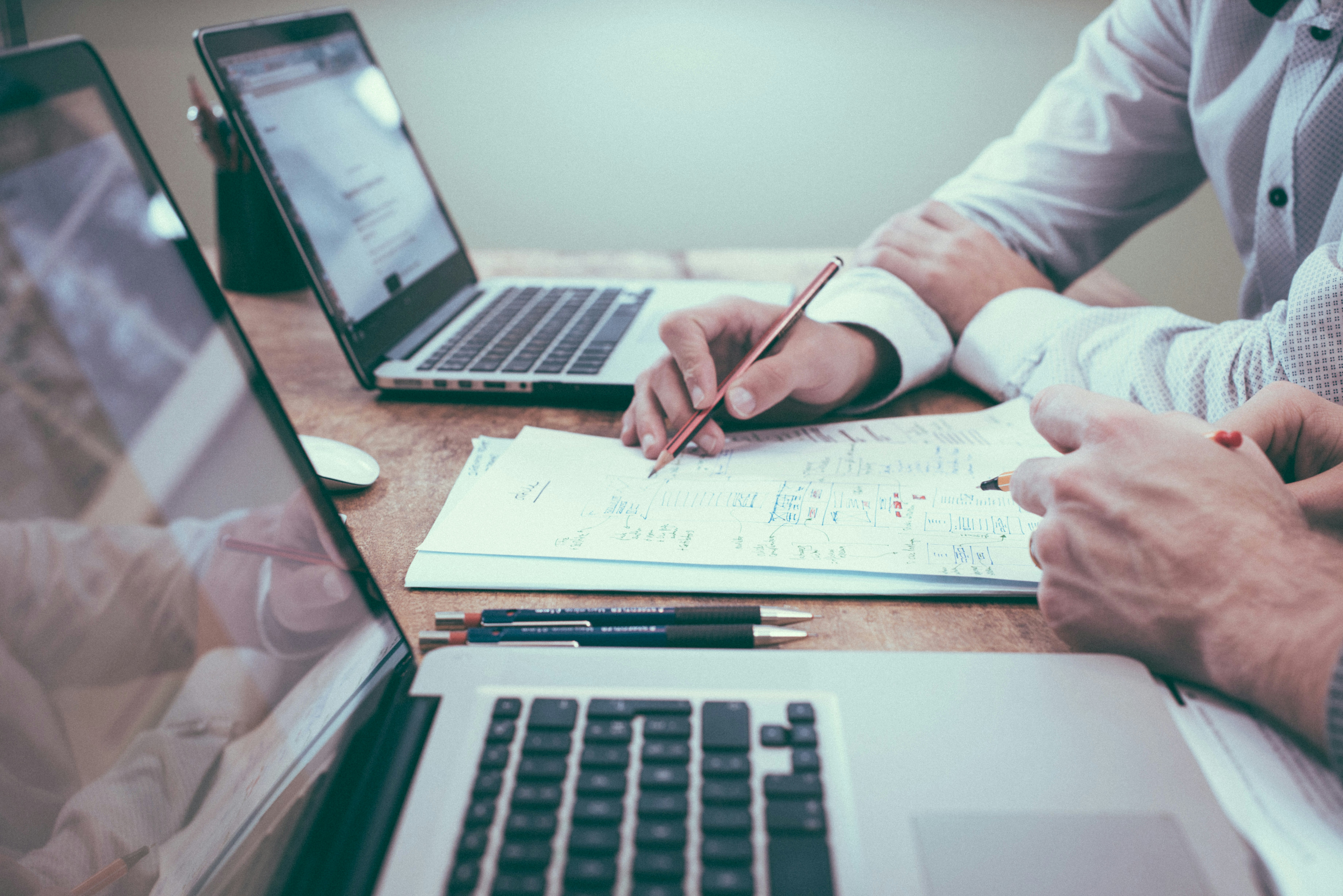 Person writing a business plan with charts and documents